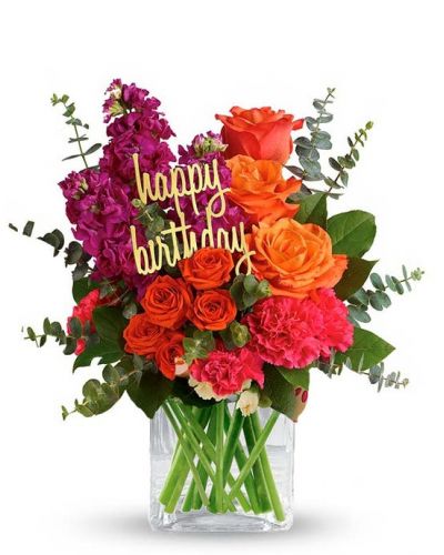 <p>Fill someone's birthday with color! This brightly colored birthday flower bouquet is created with mixed floral stems including orange roses, pink carnations and orange spray roses. All the beautiful flowers are hand arranged by a florist near you in a glass cube vase. Note: Happy Birthday pick may vary depending on local florist's availability.</p>