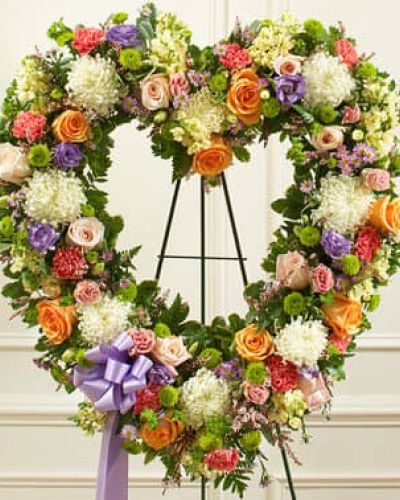 <p>During times of loss, words are not always enough to convey all the sympathy you feel in your heart. Skillfully arranged by our expert florists, this open-heart floral tribute is a fitting expression of your condolences. Crafted using delicate pastel-colored blooms, this heart-shaped arrangement features delicate pastel-colored blooms including fresh peach and pink roses, mums, stock, carnations, lisianthus and heather accented by salal, leather leaf and more. Traditionally sent directly to the funeral home by family members or friends and displayed on a stand.</p>