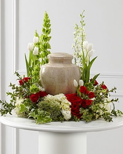 <p>The FTD® Tears of Comfort™ Arrangement is an elegant and sophisticated way to surround their urn with floral beauty at the final farewell service. Rich red roses and spray roses are vivid and bright arranged amongst white tulips, larkspur, hydrangea, and trachelium, accented with the bright greens of Bells of Ireland, hypericum berries, ivy and myrtle, creating a wonderful way to honor the life of the deceased.</p>