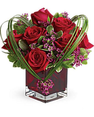 <p>You'll love the Sweet Thoughts bouquet, and you'd like to make a big impression. Send this premium version, and they'll know they've got your heart! With more roses - but the same classic, collectible cube vase in a shade of warmest crimson - this gift will be a surefire hit.<br />
A deluxe mix of red roses and purple waxflower - accented with bear grass and greenery - is delivered in a red glass cube vase.</p>